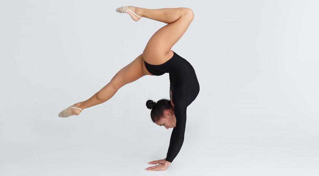 Gimnasta realizando un equilibrio invertido sobre las manos.