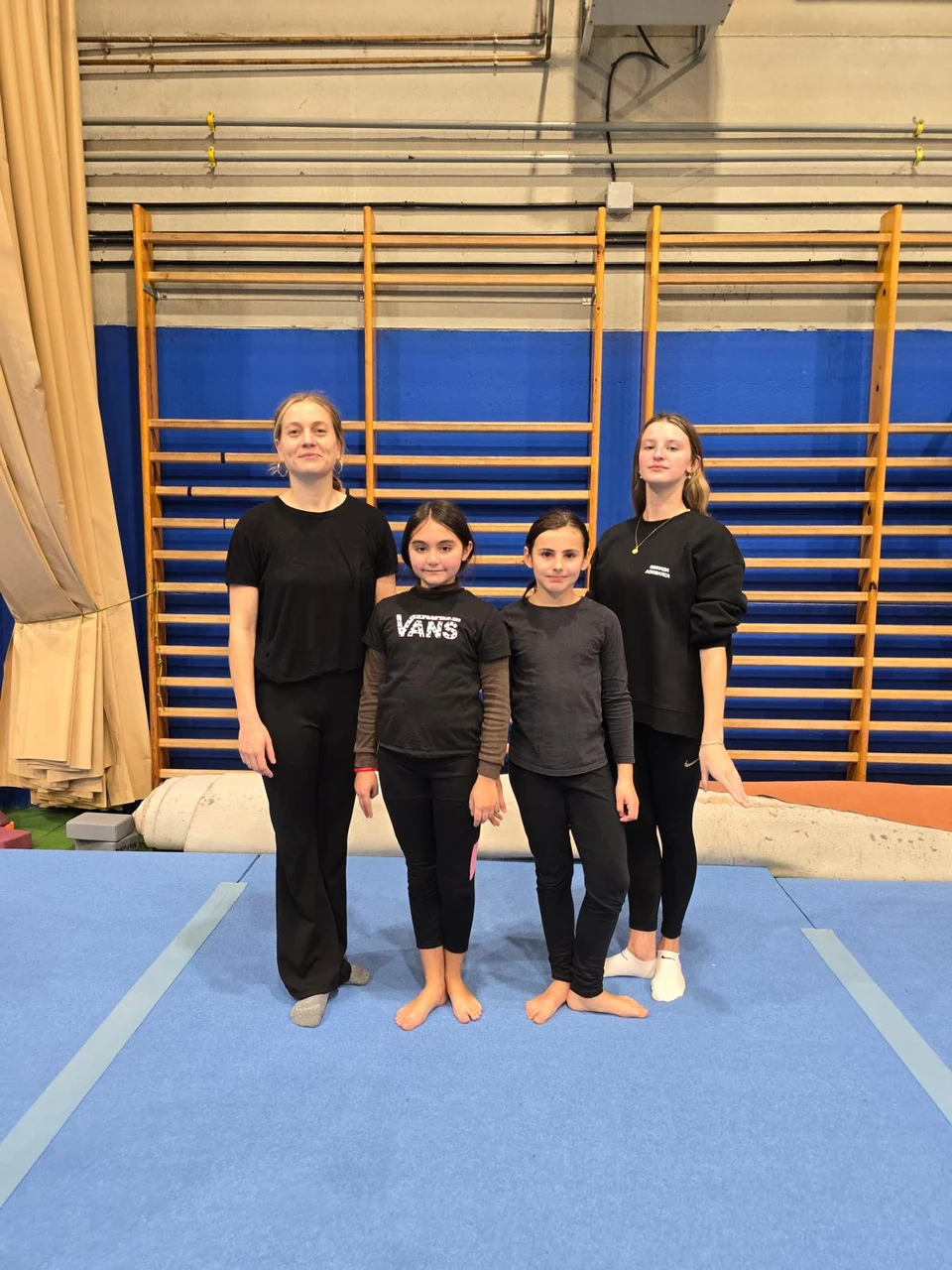 Gimnastas con sus entrenadores en el gimnasio