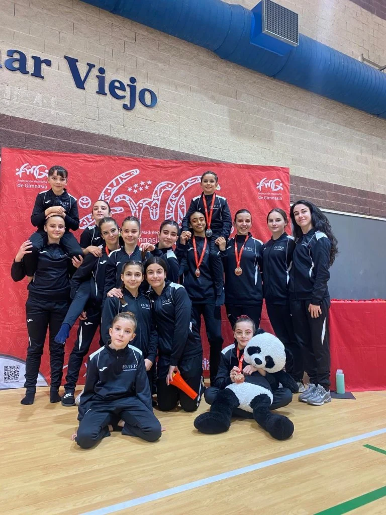 Gimnastas y entrenadoras con sus medallas